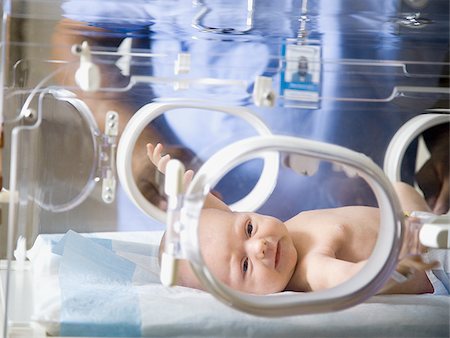 Baby in incubator with man in uniform Stock Photo - Premium Royalty-Free, Code: 640-02771732