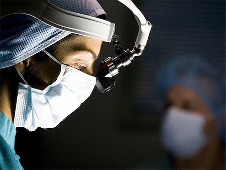 Female doctor in scrubs with head light in surgery Stock Photo - Premium Royalty-Free, Code: 640-02771769