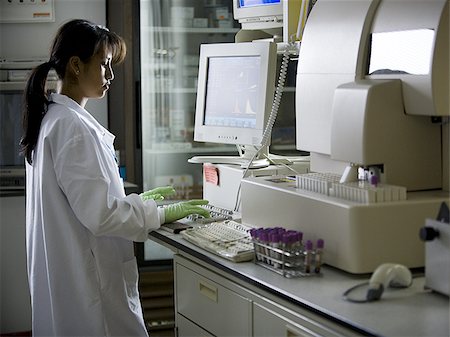 Female lab technician looking at monitors Stock Photo - Premium Royalty-Free, Code: 640-02771799