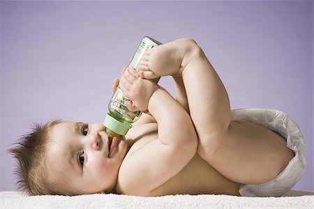 simsearch:640-01352199,k - Baby drinking from bottle with US currency in it Fotografie stock - Premium Royalty-Free, Codice: 640-02772325