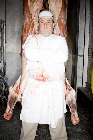 Butcher standing with hanging carcass Stock Photo - Premium Royalty-Free, Code: 640-02772395