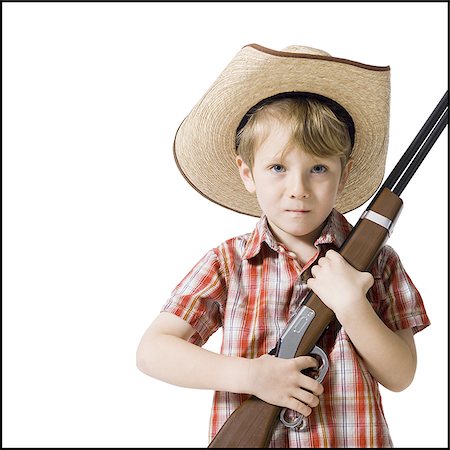 Boy with toy rifle and cowboy hat Stock Photo - Premium Royalty-Free, Code: 640-02772535