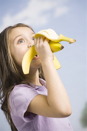 Young girl eating banana Stock Photo - Premium Royalty-Free, Code: 640-02772707