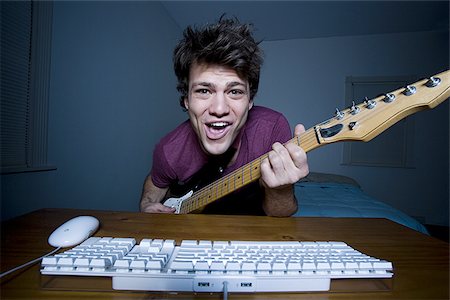 Man at keyboard playing guitar and singing Stock Photo - Premium Royalty-Free, Code: 640-02772866