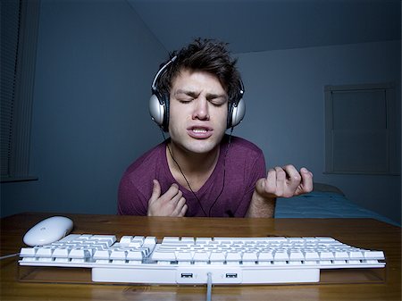 singing with head phone - Man with keyboard and headphones playing air guitar Stock Photo - Premium Royalty-Free, Code: 640-02772870