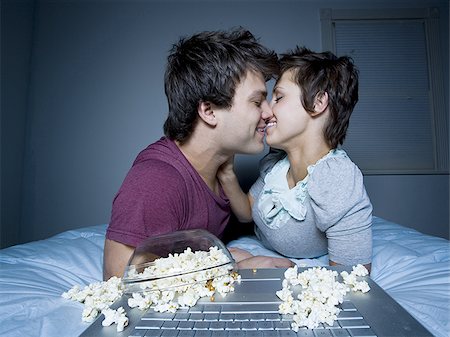 Couple kissing with upside down bowl of popcorn Stock Photo - Premium Royalty-Free, Code: 640-02772897