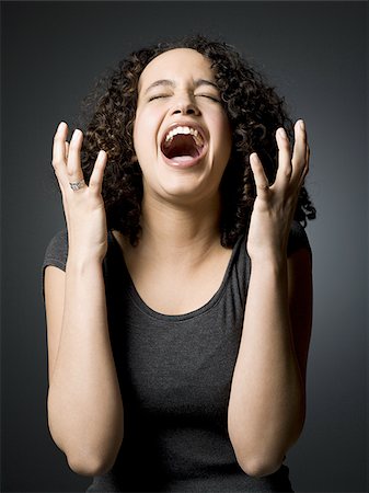 Woman with mouth open and closed eyes with hands on face Stock Photo - Premium Royalty-Free, Code: 640-02772993
