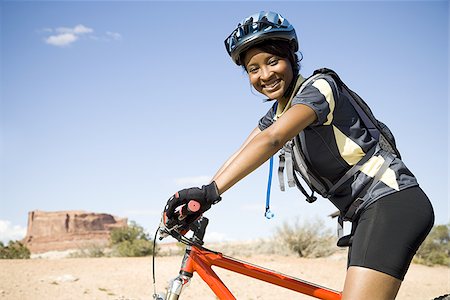 simsearch:640-02773934,k - Female cyclist with helmet outdoors smiling Foto de stock - Royalty Free Premium, Número: 640-02773184