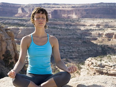 simsearch:640-03261348,k - Femme assise Croix legged sur rock en plein air faisant du yoga Photographie de stock - Premium Libres de Droits, Code: 640-02773199