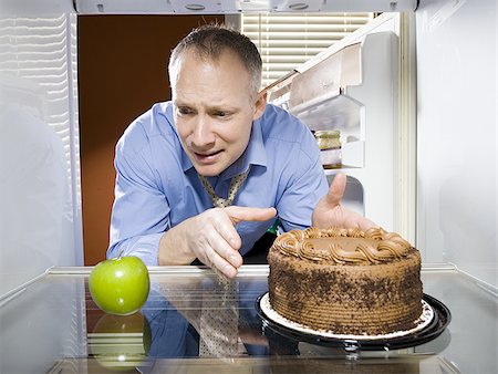 simsearch:640-02773623,k - Réfrigérateur de pomme verte, gâteau au chocolat en regardant l'homme Photographie de stock - Premium Libres de Droits, Code: 640-02773257