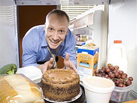 sneaky man - Man in refrigerator dipping finger in chocolate cake Stock Photo - Premium Royalty-Free, Code: 640-02773259