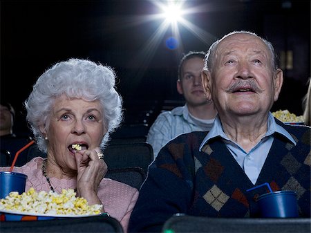 Man and woman watching film at movie theater smiling Stock Photo - Premium Royalty-Free, Code: 640-02773354