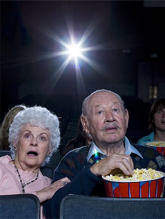 elderly couple concern - Man and woman watching film at movie theatre frightened Stock Photo - Premium Royalty-Free, Code: 640-02773367