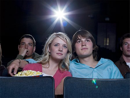 simsearch:640-02773489,k - Boy and girl watching film at movie theater smiling Fotografie stock - Premium Royalty-Free, Codice: 640-02773375