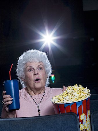 person cowering in fear - Woman watching film at movie theatre frightened Stock Photo - Premium Royalty-Free, Code: 640-02773371