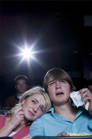 Boy and girl with tissues crying at movie theater Stock Photo - Premium Royalty-Free, Code: 640-02773398