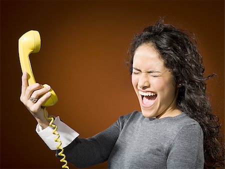 Woman holding retro phone and yelling Stock Photo - Premium Royalty-Free, Code: 640-02773443