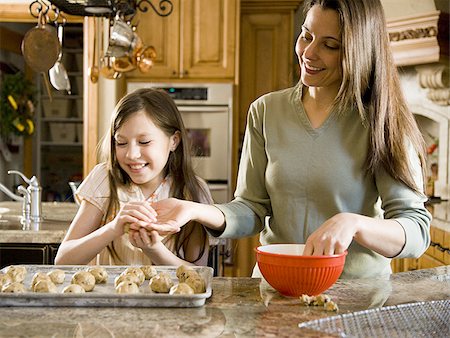 Girl in kitchen with woman baking cookies Stock Photo - Premium Royalty-Free, Code: 640-02773562