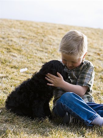 simsearch:640-01355830,k - Boy sitting on grass outdoors with puppy Stock Photo - Premium Royalty-Free, Code: 640-02773576