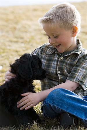 simsearch:640-01355830,k - Boy sitting on grass outdoors with puppy Stock Photo - Premium Royalty-Free, Code: 640-02773578