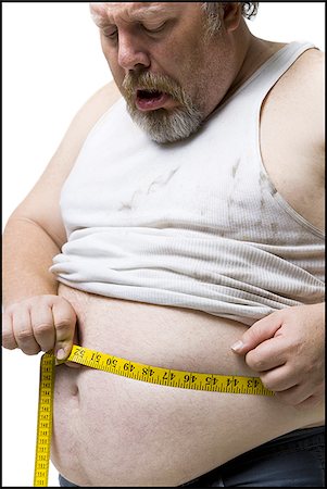 Obese man measuring waist with tape measure Stock Photo - Premium Royalty-Free, Code: 640-02773760