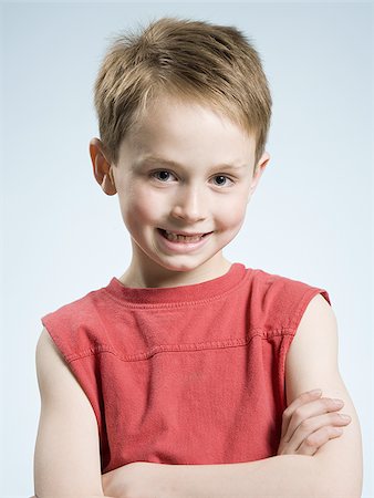 Boy smiling with arms crossed Stock Photo - Premium Royalty-Free, Code: 640-02773776