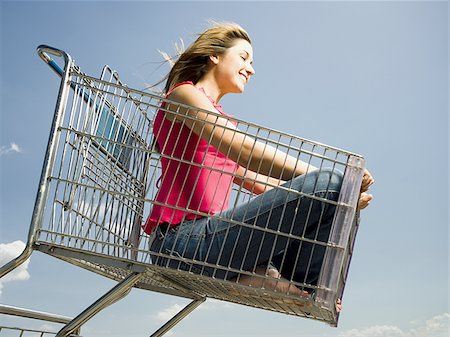 simsearch:640-02773934,k - Woman in shopping cart outdoors with arms up smiling Foto de stock - Royalty Free Premium, Número: 640-02773933