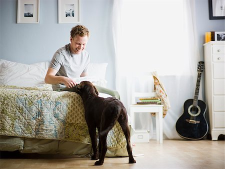 dog in bed - man in his bedroom with his dog Stock Photo - Premium Royalty-Free, Code: 640-02947572