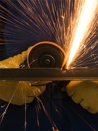 man in blue coveralls with a power grinder Stock Photo - Premium Royalty-Free, Code: 640-02947748