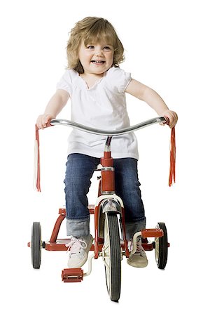 little girl on a tricycle Stock Photo - Premium Royalty-Free, Code: 640-02947803