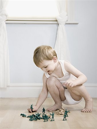 little boy playing with toy soldiers Stock Photo - Premium Royalty-Free, Code: 640-02947959