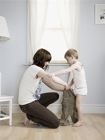 mother dressing her son Stock Photo - Premium Royalty-Free, Code: 640-02947961