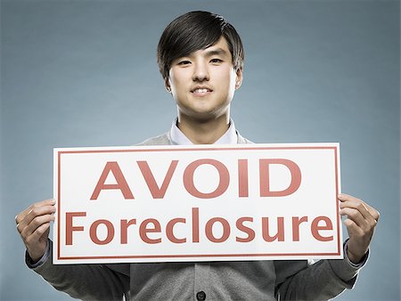 man holding an "avoid foreclosure" sign Stock Photo - Premium Royalty-Free, Code: 640-02948686