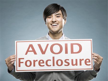 man holding an "avoid foreclosure" sign Stock Photo - Premium Royalty-Free, Code: 640-02948687