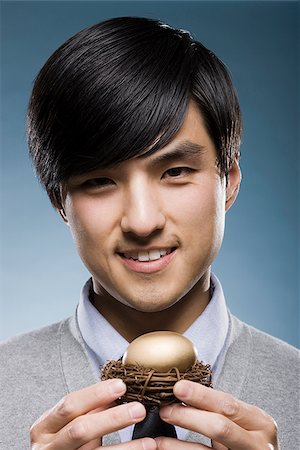 simsearch:640-02950509,k - man holding a golden egg in a nest Foto de stock - Sin royalties Premium, Código: 640-02948699