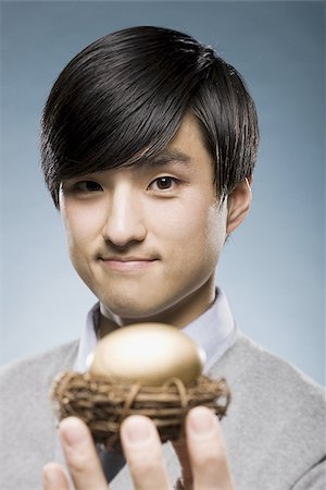 simsearch:640-02950509,k - man holding a golden egg in a nest Foto de stock - Sin royalties Premium, Código: 640-02948701