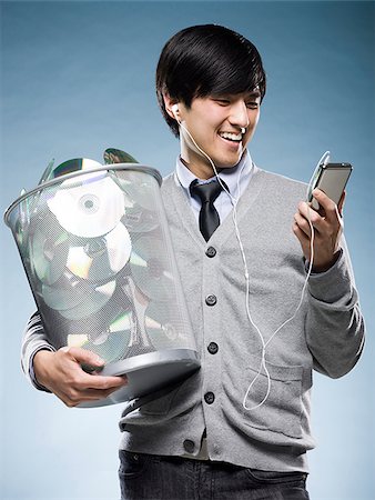 simsearch:640-02948690,k - homme avec une poubelle peut plein de cd et tenant un iPod Photographie de stock - Premium Libres de Droits, Code: 640-02948717