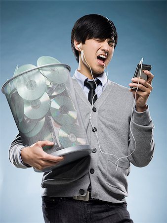 man with a trash can full of cd's and holding an iPod Stock Photo - Premium Royalty-Free, Code: 640-02948719