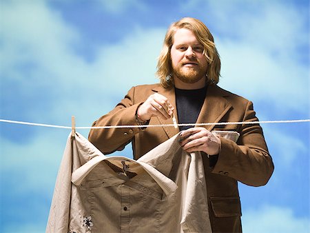 man hanging shirt on a clothesline Stock Photo - Premium Royalty-Free, Code: 640-02949221
