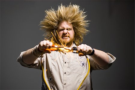 man with crazy hair holding jumper cables Stock Photo - Premium Royalty-Free, Code: 640-02949250