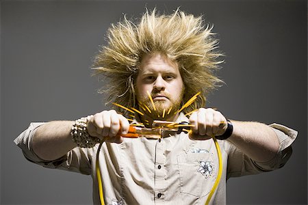 man with crazy hair holding jumper cables Stock Photo - Premium Royalty-Free, Code: 640-02949252