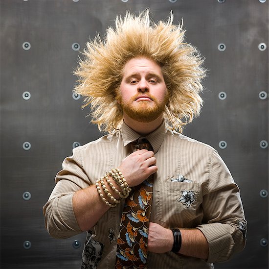 man with crazy hair fixing tie Stock Photo - Premium Royalty-Free, Image code: 640-02949253