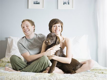 couple on their bed with their dog Stock Photo - Premium Royalty-Free, Code: 640-02949322