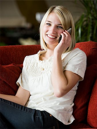 simsearch:640-02948353,k - woman using her cell phone on a red sofa Foto de stock - Royalty Free Premium, Número: 640-02949586