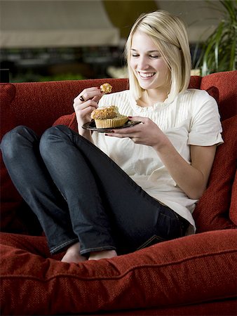 simsearch:640-02948353,k - woman eating a muffin on a red sofa Foto de stock - Royalty Free Premium, Número: 640-02949580