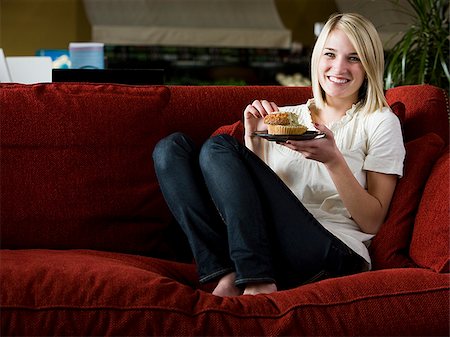 simsearch:640-02948353,k - woman eating a muffin on a red sofa Foto de stock - Royalty Free Premium, Número: 640-02949581
