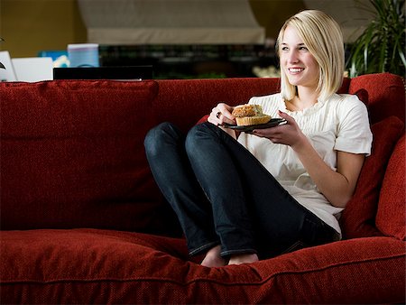 simsearch:640-02948353,k - woman eating a muffin on a red sofa Foto de stock - Royalty Free Premium, Número: 640-02949582