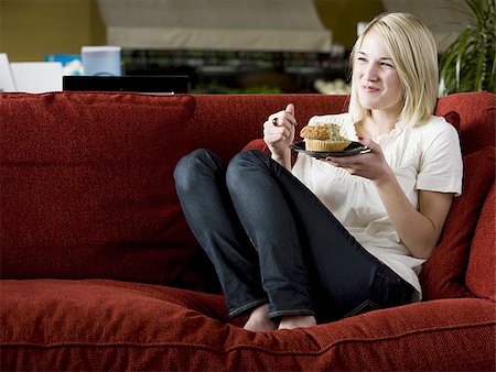 simsearch:640-02948353,k - woman eating a muffin on a red sofa Foto de stock - Royalty Free Premium, Número: 640-02949583