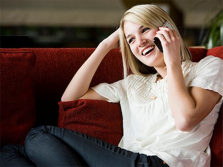 simsearch:640-02948353,k - woman using her cell phone on a red sofa Foto de stock - Royalty Free Premium, Número: 640-02949590