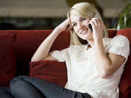 simsearch:640-02948353,k - woman using her cell phone on a red sofa Foto de stock - Royalty Free Premium, Número: 640-02949592